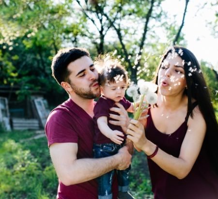 Familia alegre con flores razones para regalar flores