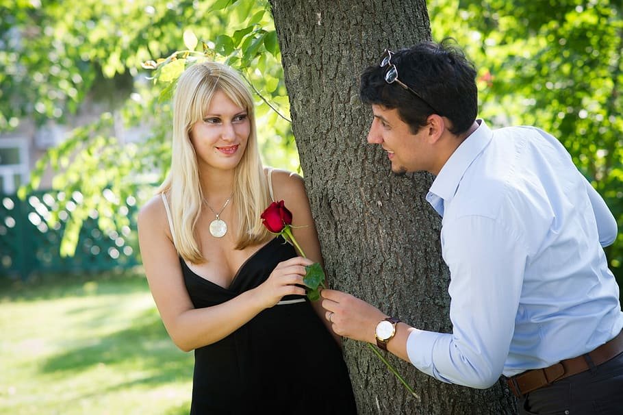 Hombre regalando una flor a una mujer obsequio para una cita